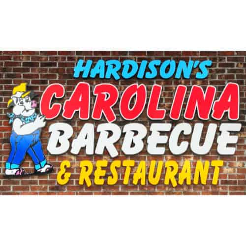 Sign for Hardison's Carolina Barbecue & Restaurant on a brick wall, with a cartoon pig in overalls and a hat.